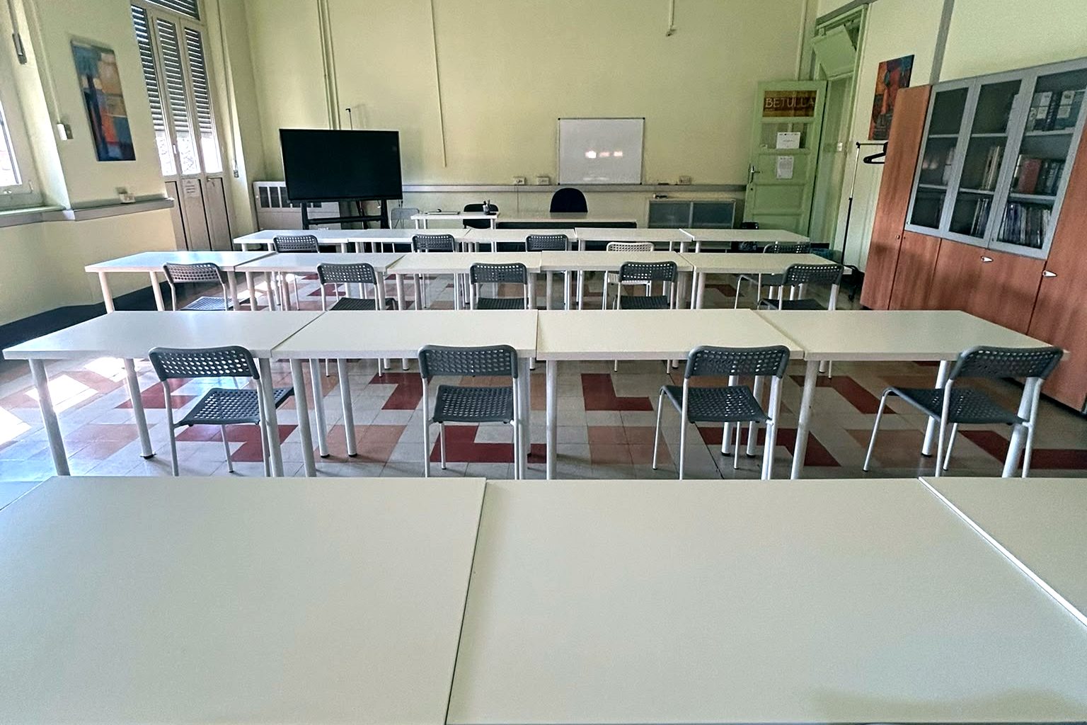 Aula di Effetto a Torino, Corso Trapani 25: tavoli bianchi, sedie e schermo